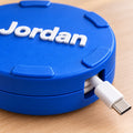 Personalized cable spool with the name Jordan, USB-C cable through side opening